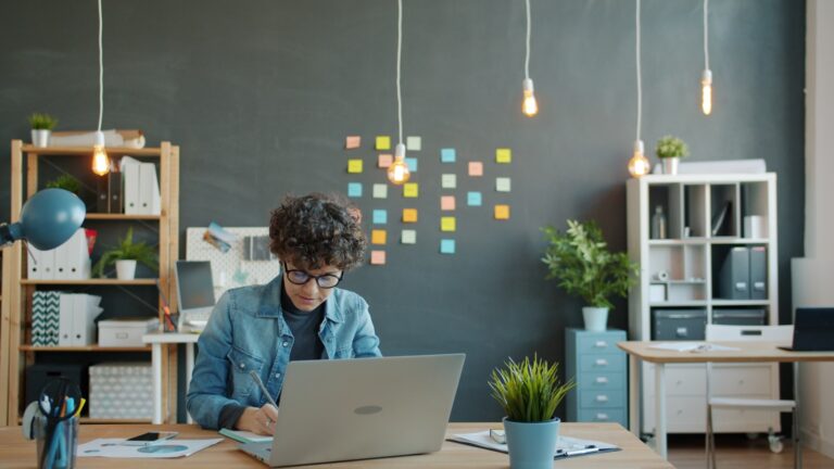 Young person working on a laptop in a modern office.