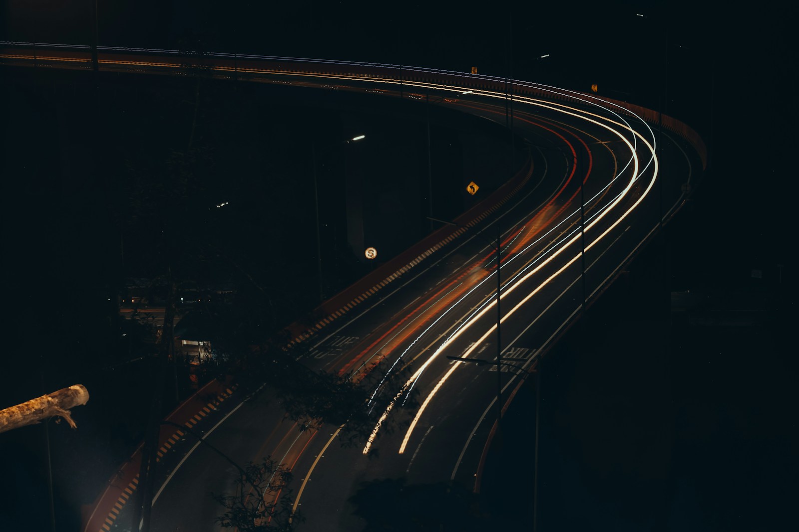 A man standing on the side of a road at night